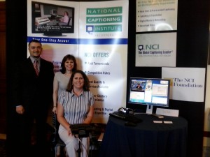 Anthony DeMarco, Connie Templin, and Darlene Parker pose in front of the NCI display