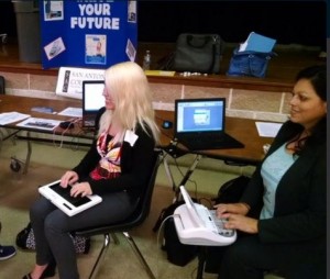 A court reporting student and a court reporter writing on their steno machines at a career fair