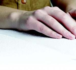 close-up of fingers reading braille