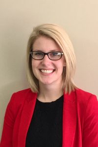 Photo of Rachel Ellefson: a young woman with blond hair in a red blazer