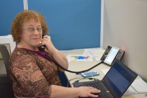 Kathy Cortopassi on the phone sitting at a desk