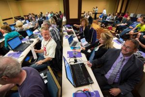 Contestants for the 2014 Realtime Contest before the contest begins. Many look congenial. They sit in rows with their laptops and steno machines in front of them. In the back are about a dozen observers.