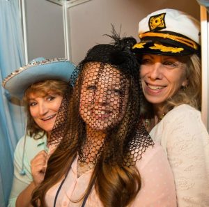 Three smiling women in funny hats