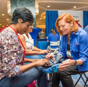 A steno machine company rep sits one-on-one with a woman to try out a new machine