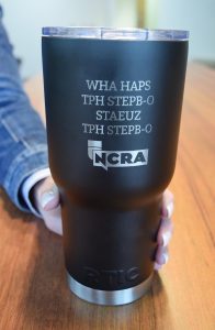 Tumbler with NCRA logo and text: WHA HAPS TPH STEPB-O STAEUZ TPH STEPB-O