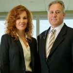 Photo of NCRF Major Gifts donors: A man and a woman in professional attire stand side by side in an office