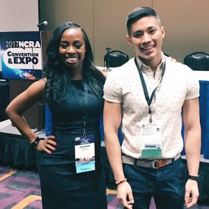 A young woman and a young man stand next to each other smiling