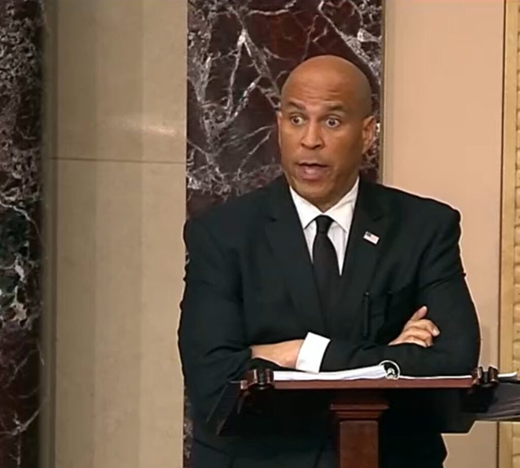 Senator Cory Booker standing at a podium speaking