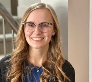 A woman with long blonde hair, wearing glasses