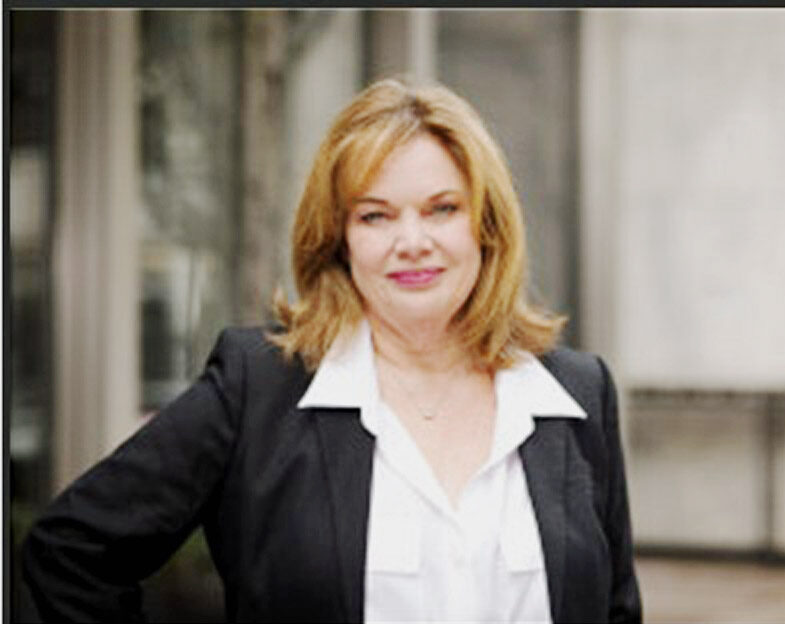 Woman standing in a business suit smiling