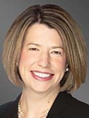 Professional headshot of woman with short brown hair smiling at the camera