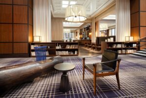 Hotel lobby with chairs, a chandelier, and a bench