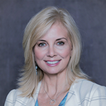 Headshot of a blond woman smiling at the camera