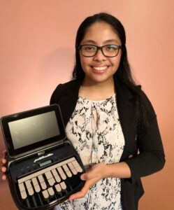 Woman smiling and holding a steno machine