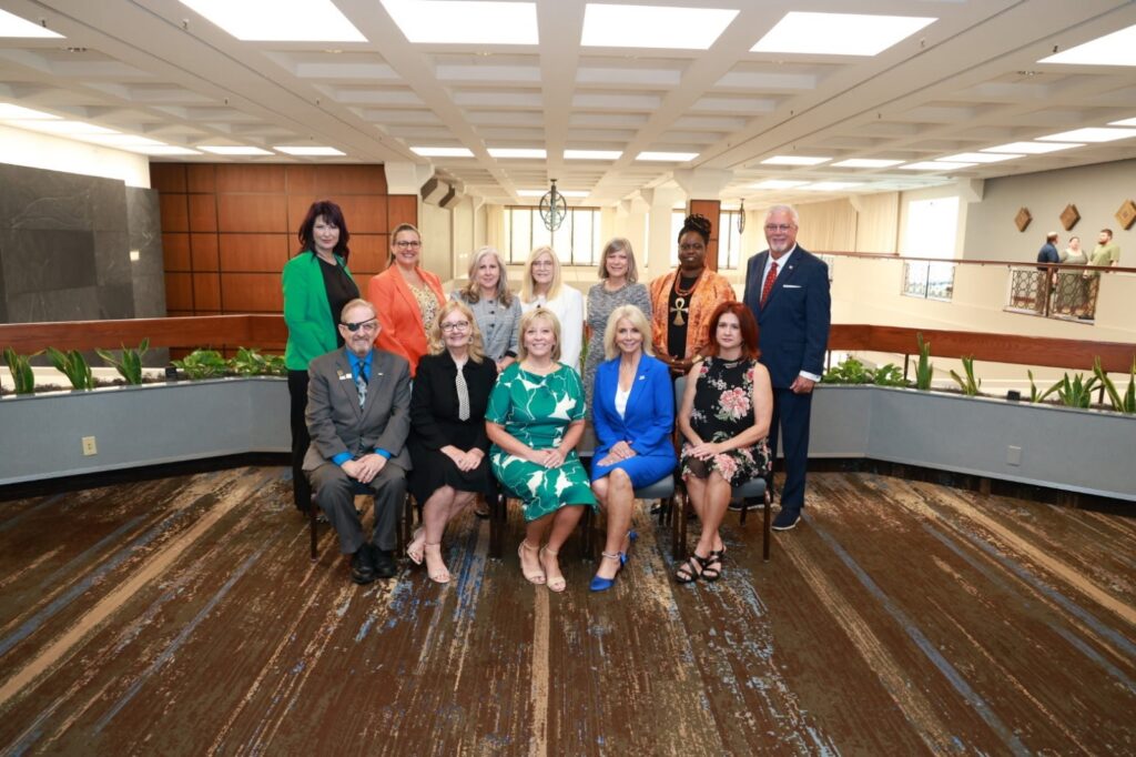 Groupf of professional people seated and standing posing for a picture