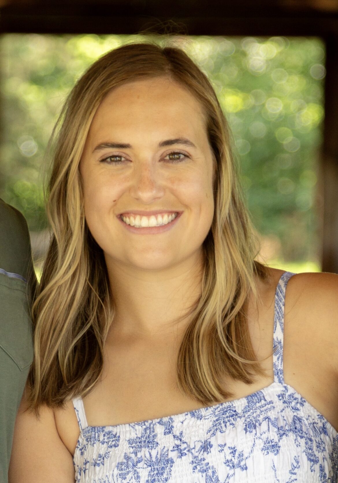 Blonde woman in a sundress smiling at the camera