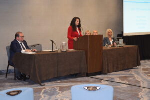 people at a dais presenting at a meeting