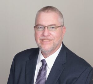 Professional headshot of a man in suit and tie