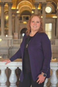 Woman standing in a marble atrium, posing for the camera