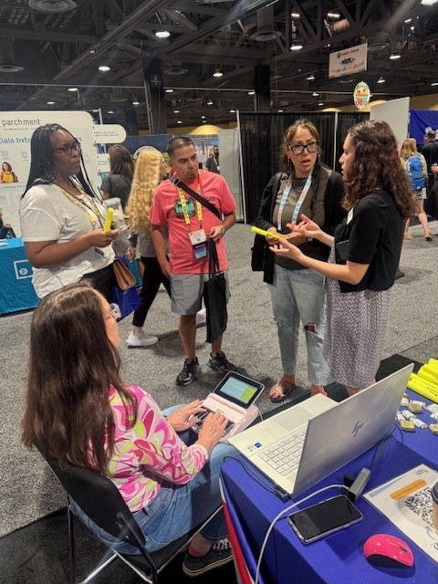 Attendees at a conference gathered around a stenographer