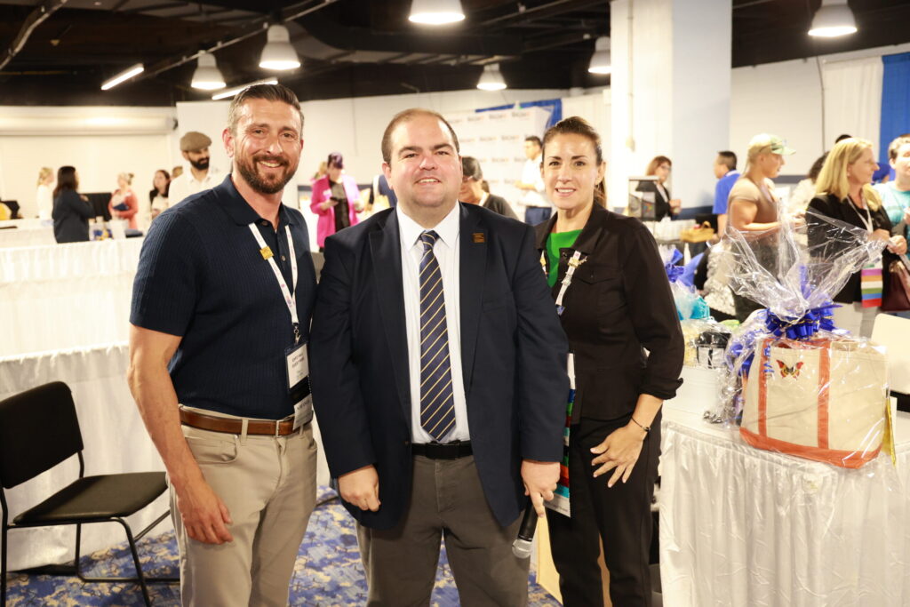 A group of people standing in a room smiling at the camera