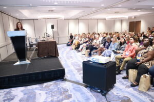 A crowd watching a presentation at a conference