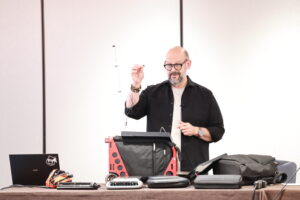 A man at a podium demonstrating steno equipment