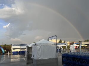 A rainbow over a tent in a parking lot