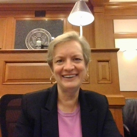 A woman in a courtroom smiling at the camera