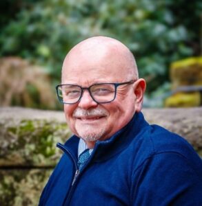 A man in glasses smiling at the camera