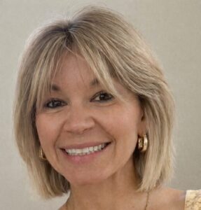 Blonde woman smiling at a camera