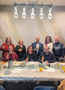 A group of people standing for a photo around a table