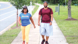 Woman and man walking on a sidewalk