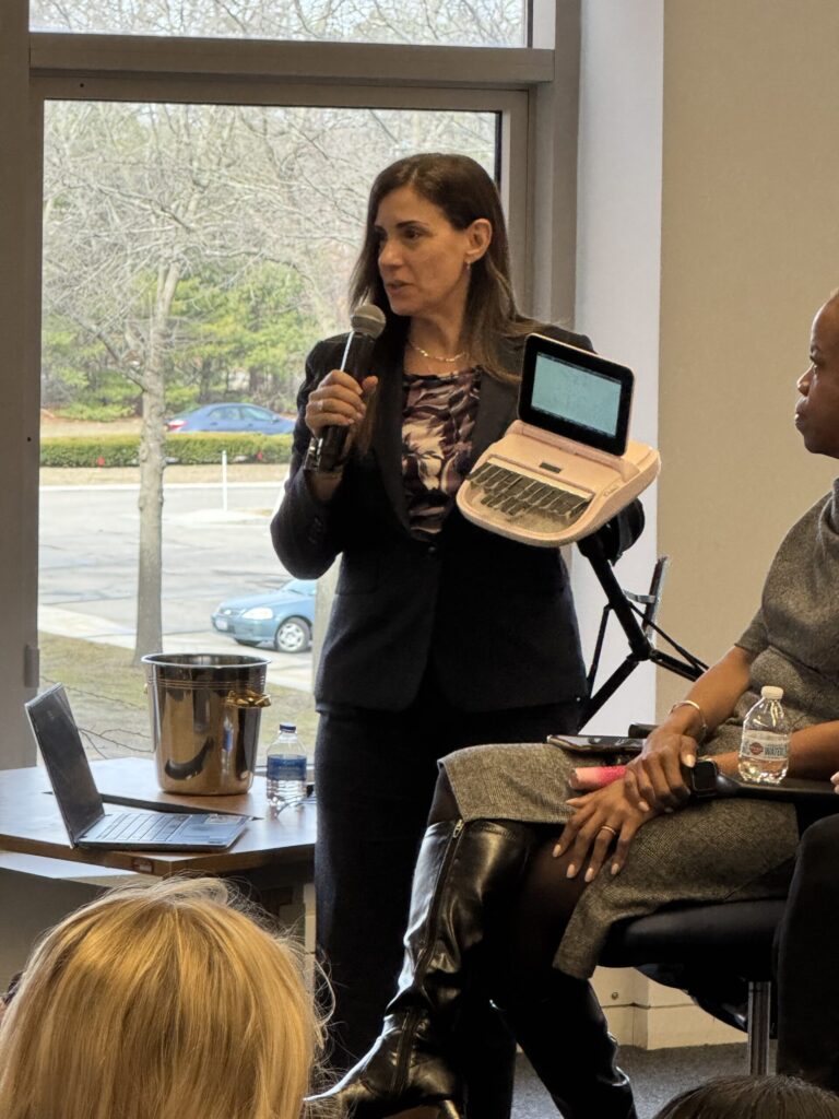 A woman standing holding a microphone and a steno maching