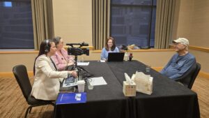 A group of people seated around a table conducting an interview