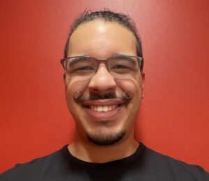 Headshot of a man in glasses smiling