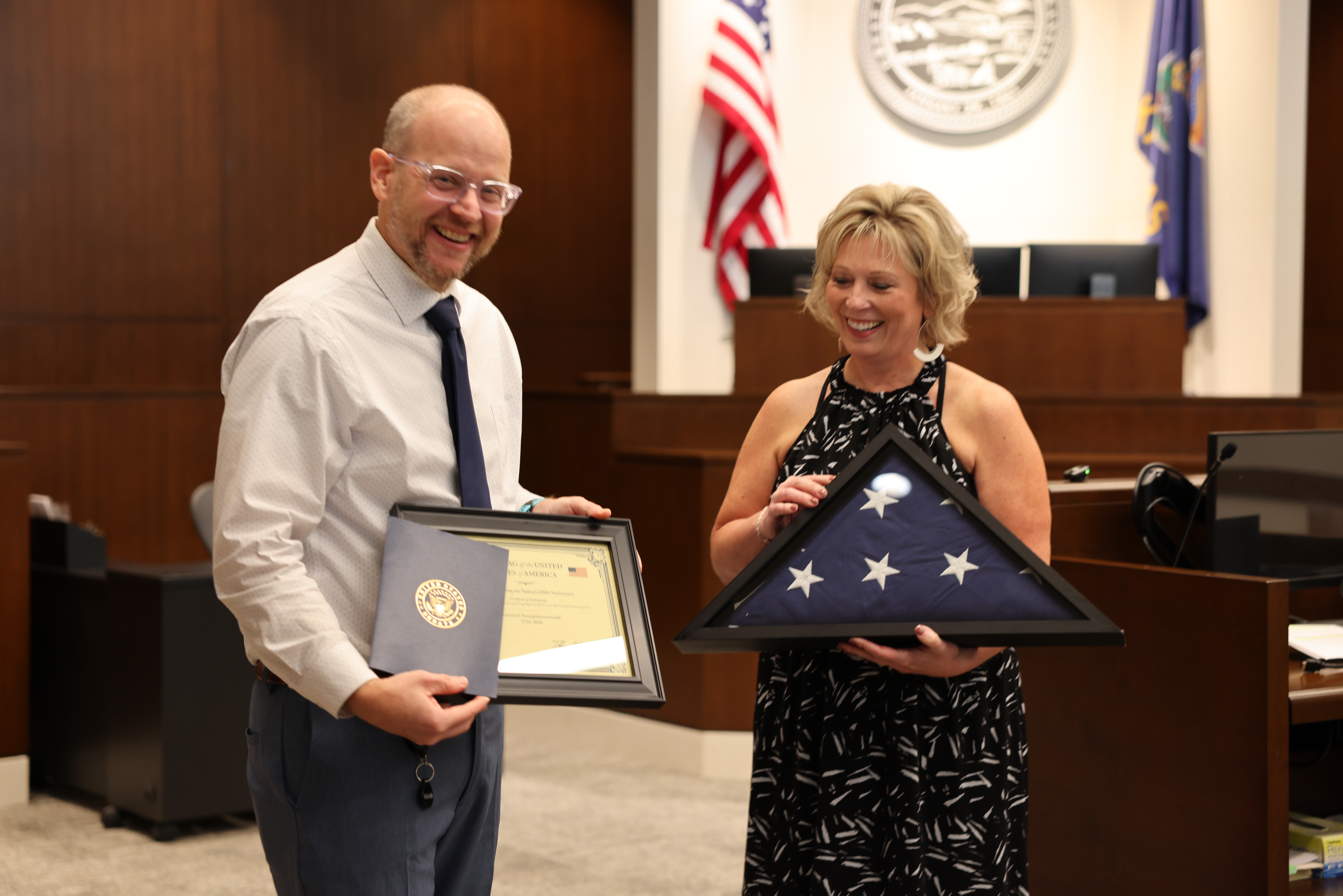 Cindy Isaacsen presenting a flag to Judge Robert J. Wonnell